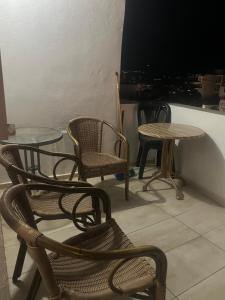a group of chairs and tables and a television at Private Rooms with a Beautiful Veranda in Heraklio
