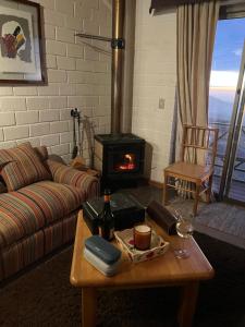 a living room with a couch and a wood stove at Refugio de Montaña, excepcional in El Colorado