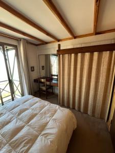 a bedroom with a bed and a window with a desk at Refugio de Montaña, excepcional in El Colorado