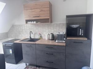 a small kitchen with a sink and a microwave at Monteurwohnung Weigl in Großmehring