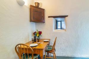 a wooden table with chairs and a wooden cabinet at 1 Bed in Llanrwst oc-wag232 in Llanrwst