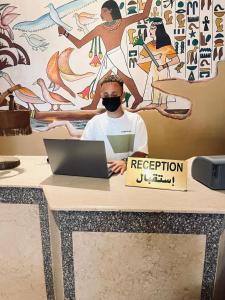 Ein Mann mit einer Virtual-Reality-Brille sitzt mit einem Laptop an einem Tisch in der Unterkunft KR Elite Hotel in Luxor + 86 Fotos