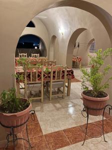 ein Esszimmer mit Tisch, Stühlen und Pflanzen in der Unterkunft KR Elite Hotel in Luxor