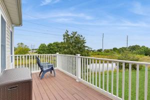 a porch with a blue chair on a wooden deck at Bear Trap Dunes --- 124 October Glory Ave Unit #B in Ocean View