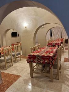 ein Esszimmer mit Tischen und Stühlen und einem Fernseher in der Unterkunft KR Elite Hotel in Luxor