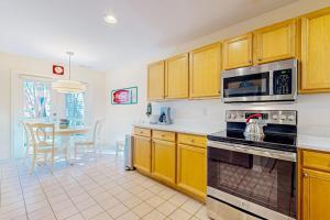 a kitchen with wooden cabinets and a stove top oven at Sea Colony --- 56200 Pine Cone Ln in Bethany Beach