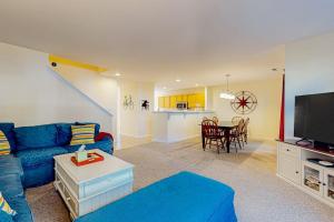 a living room with a blue couch and a kitchen at Sea Colony --- 56200 Pine Cone Ln in Bethany Beach
