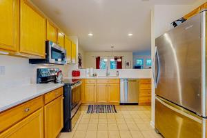 a kitchen with yellow cabinets and a stainless steel refrigerator at Sea Colony --- 56200 Pine Cone Ln in Bethany Beach +38 photos