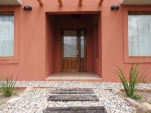 a orange house with a wooden door in front at La Celina Casas de Campo in Nono