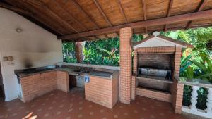 an outdoor kitchen with a sink and a fireplace at Villa Jardín Con piscina y jacuzzi in Bonda