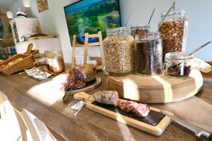 a table with jars of food and meat on it at Hôtel & Restaurant Les Mouettes in Belgodère