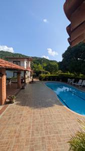 a resort with a swimming pool and a building at Villa Jardín Con piscina y jacuzzi in Bonda