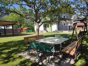 a picnic table and chairs under a tree in a park at Ferienhaus Mauthen 206 in Kötschach