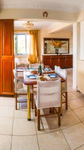 a dining room with a wooden table and chairs at Villa Rodothea in Khelmáta