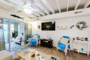 a living room with blue chairs and a tv at Mallard Lakes --- 38082 Mockingbird Ln Unit #48 in Selbyville