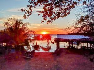 a sunset over a body of water with a house at Poneloya Budget Accomodations in León