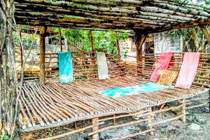 a woven bench sitting under a wooden structure at Poneloya Budget Accomodations in León
