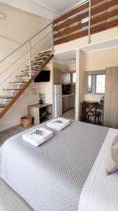 a bedroom with a large white bed and a staircase at Danny Arz Apartments in Iraklitsa