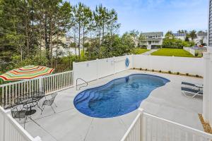 a swimming pool on a patio with tables and chairs at 39609 Waterworks Ct in Bethany Beach