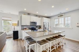 a kitchen with a large island with bar stools at 39609 Waterworks Ct in Bethany Beach +20 photos