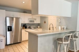 a kitchen with white cabinets and a stainless steel refrigerator at Sea Colony --- 55032 Pine Lake Dr in Bethany Beach