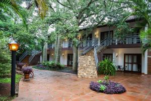 a building with a staircase and trees and a street light at Nobile Hotel Papillon in Bella Vista