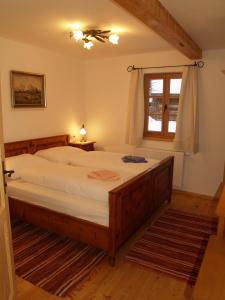 sypialnia z dużym łóżkiem i oknem w obiekcie Apartments Stegmühle w mieście Mauterndorf