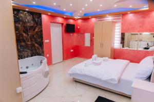 a bathroom with a white bed and a bath tub at Lux apartmani Savić in Aleksinac