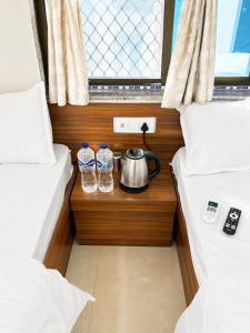 a room with two beds with water bottles and a tea kettle at Hotel Virat Palace 600 From Khatu Shyam Ji in Khātu