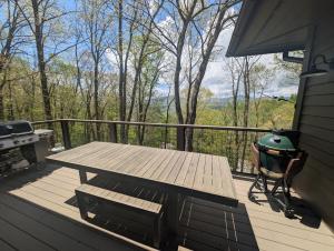 a picnic table and a grill on a deck with a view at 4 Pines in Boone