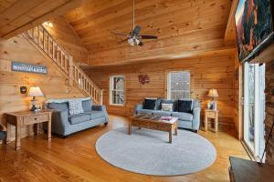 a living room with couches and a ceiling fan at Little Elk Lodge in Elk Park