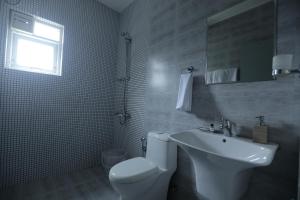 a bathroom with a white toilet and a sink at Two Seas Residence - Boutique Residences in Ooty +174 photos