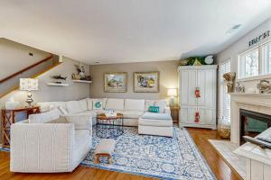 a living room with a white couch and a fireplace at Sea Colony - 55073 Pine Shore in Bethany Beach