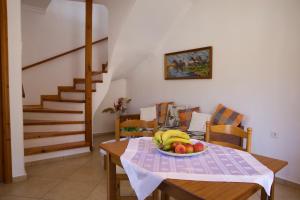 a dining room table with a plate of fruit on it at Soustas Apartments in Longós
