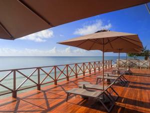 a balcony with two chairs and an umbrella at Royal Mandarin Hotel & Resort Zanzibar in Pwani Mchangani