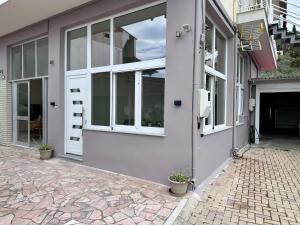 ein Gebäude mit Tür und Fenstern auf einem Bürgersteig in der Unterkunft Rodia 2 in Pteleos