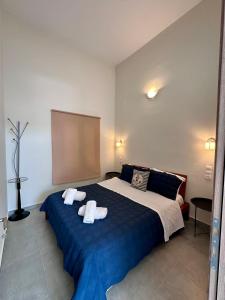 ein Schlafzimmer mit einem blauen Bett, auf dem Handtücher liegen in der Unterkunft Rodia 2 in Pteleos
