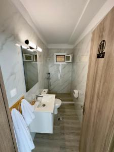 ein weißes Badezimmer mit Waschbecken und Spiegel in der Unterkunft Rodia 2 in Pteleos + 7 Fotos