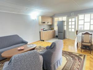 a living room with a couch and a table at Guest House Chkalovka Garden in Sevan
