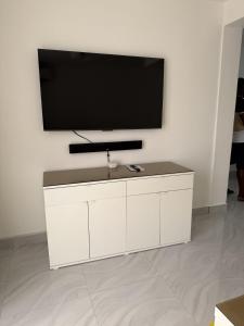 a white cabinet with a flat screen tv on a wall at Modern Tropical Oasis in Sosúa