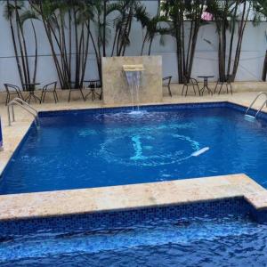 a swimming pool with a fountain in the middle at Modern Tropical Oasis in Sosúa