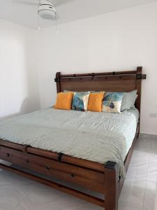a wooden bed with pillows on it in a bedroom at Modern Tropical Oasis in Sosúa +7 photos