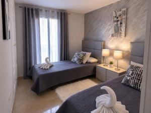 a bedroom with two beds and a window at Duquesa Coto Real in Manilva +10 photos