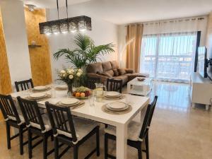a living room with a dining room table with chairs at Duquesa Coto Real in Manilva