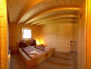 a room with two beds in a wooden room at Waldsiedlung - Haus 10 in Großkoschen