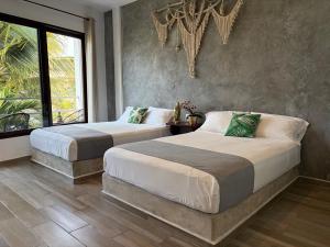 a bedroom with two beds and a large window at Hotel Lunazul In Costa Esmeralda in La Vigueta