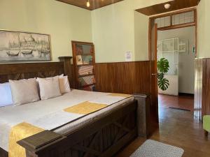a bedroom with a large bed with a wooden frame at Hotel Muchá in Quetzaltenango