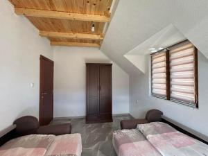 two beds in a room with wooden ceilings at Etno village Bare in Bare