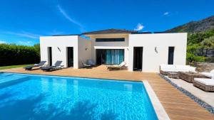 a villa with a swimming pool in front of a house at Villa , Piscine Privée, Jacuzzi in Barbaggio