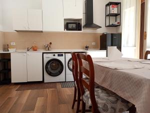 eine Küche mit Waschmaschine und einem Tisch mit Stühlen in der Unterkunft Cozy!! Verona in Verona